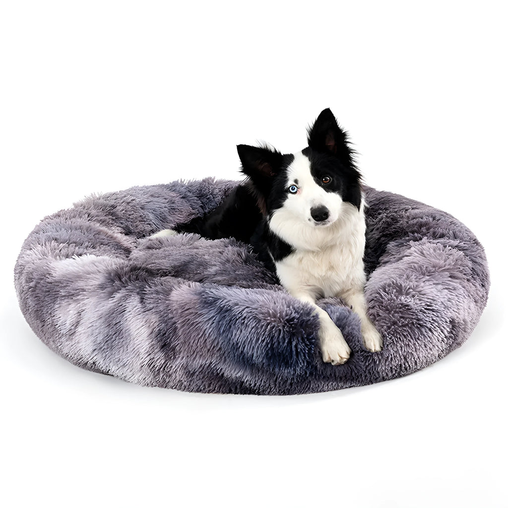 Fluffy donut-shaped dog bed in long plush material, showing raised rim and central cushion.