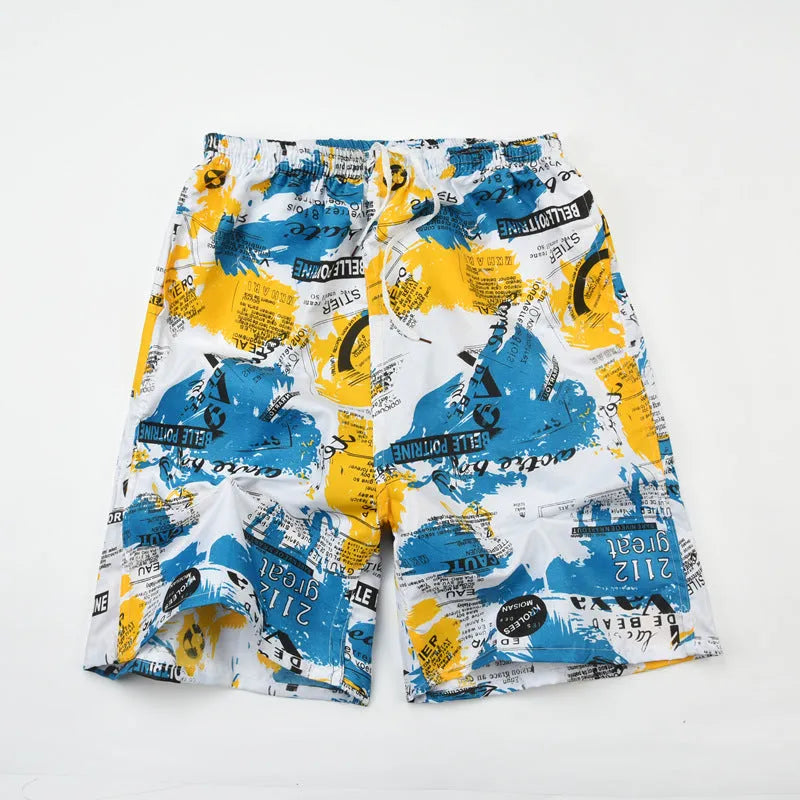 Man wearing floral print swimming trunks at the beach, showing the loose fit and colourful pattern.