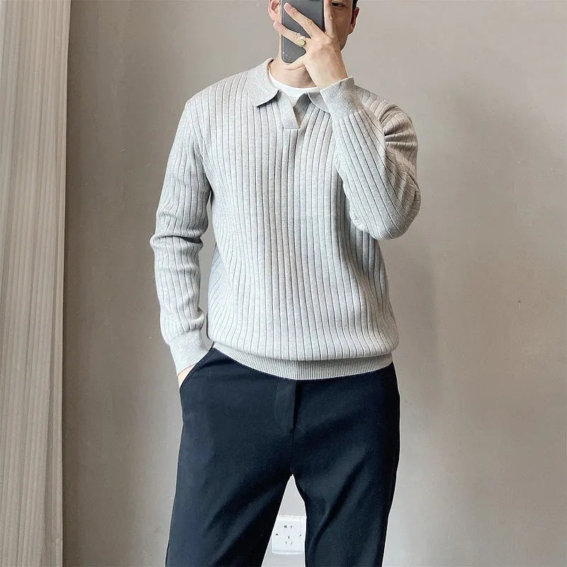 Man wearing a black and white striped knitted jumper with a lapel collar.