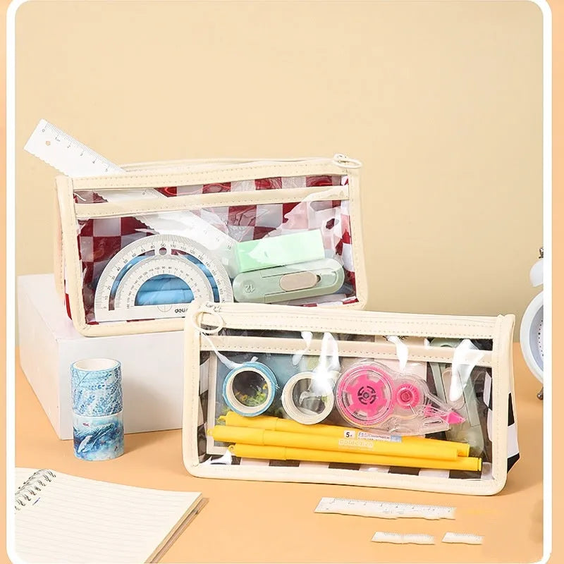 Transparent PVC pencil case with chessboard grid pattern showing pens inside, measuring 21.5cm long