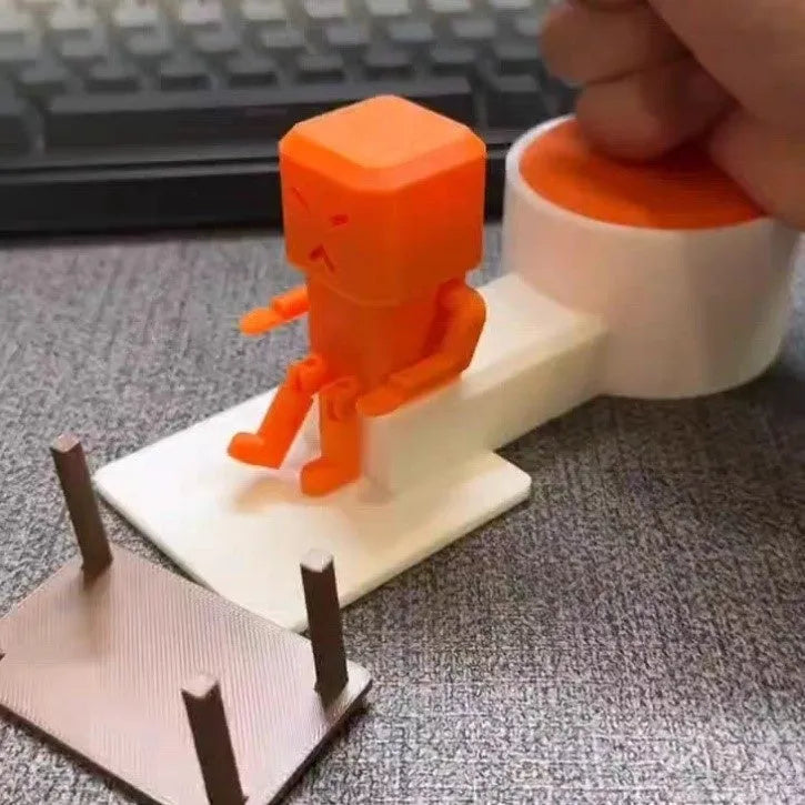 Orange plastic vent decompression toy with push buttons on a desk