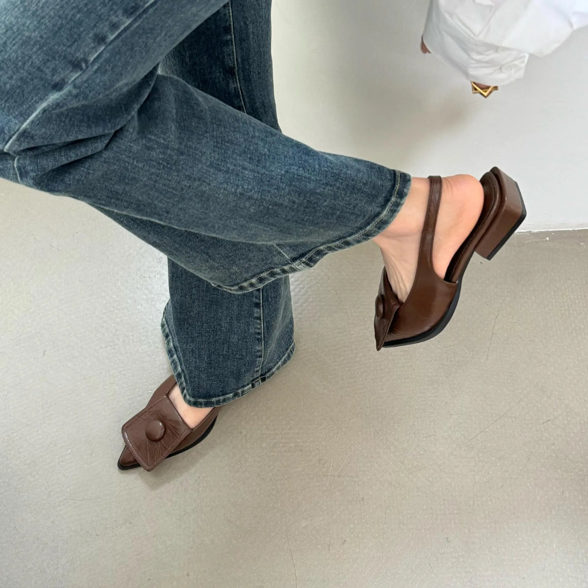 Women's low heel pointed toe sandals with a back strap in black, shown from the side.