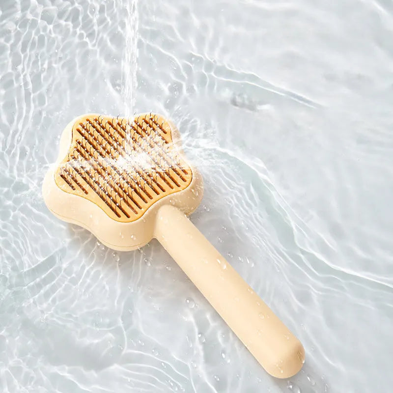 Green self-cleaning cat comb with stainless steel pins on a white background