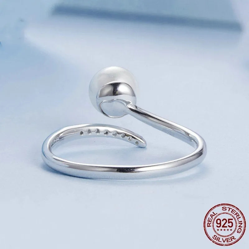 Silver adjustable ring with natural pearl centrepiece showing open loop design