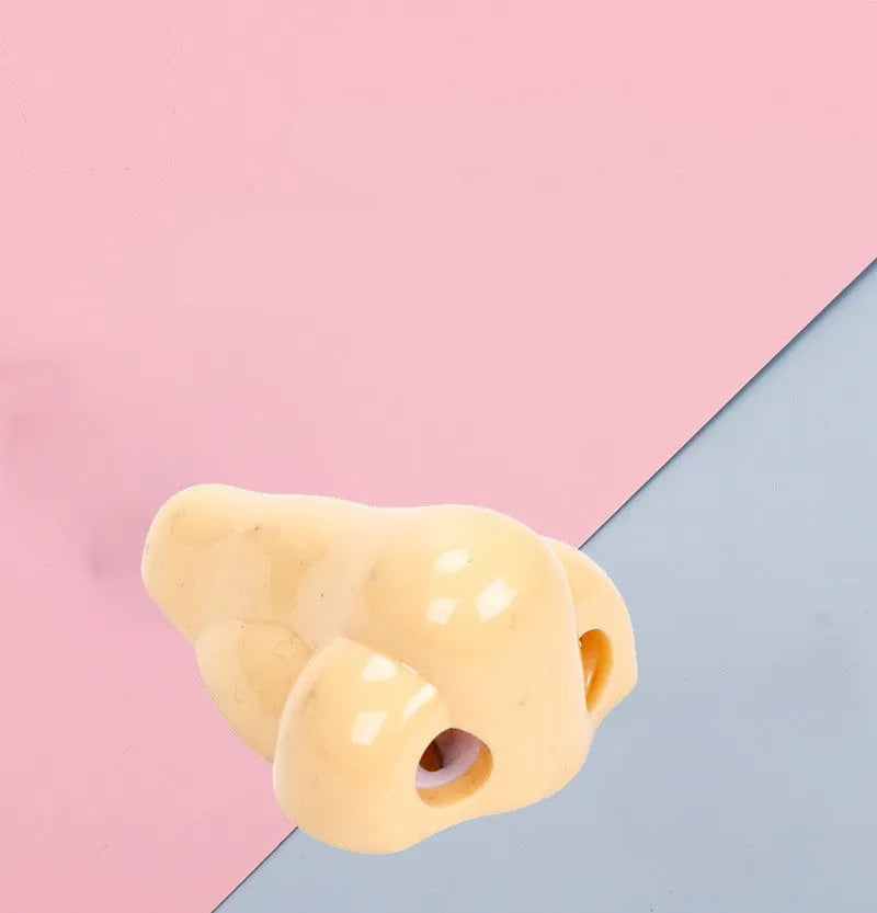 Flesh coloured geometry-shaped plastic manual pencil sharpener on a white background.