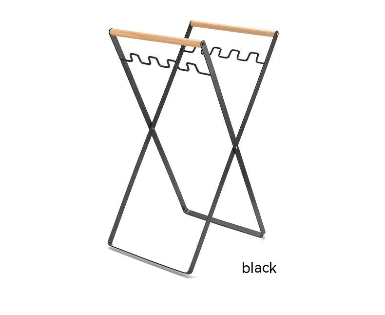 Black folding iron outdoor trash rack with a wooden handle holding a waste bag.
