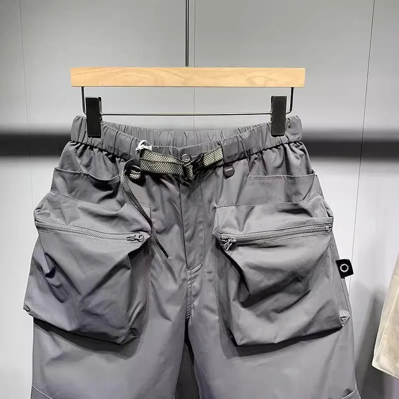 Men's loose fit grey workwear shorts with pockets, shown above the knee.
