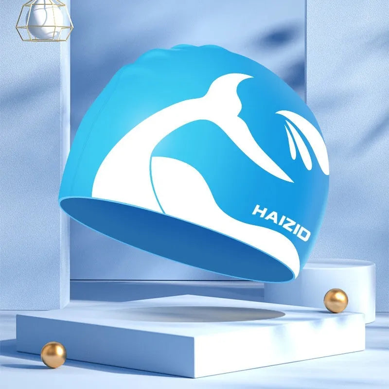 Silicone swim cap with whale tail pattern and built-in ear protectors in assorted colours.