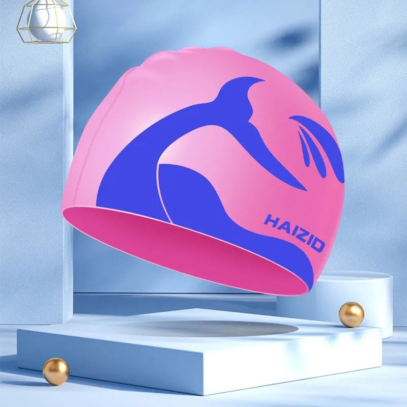 Silicone swim cap with whale tail pattern and built-in ear protectors in assorted colours.