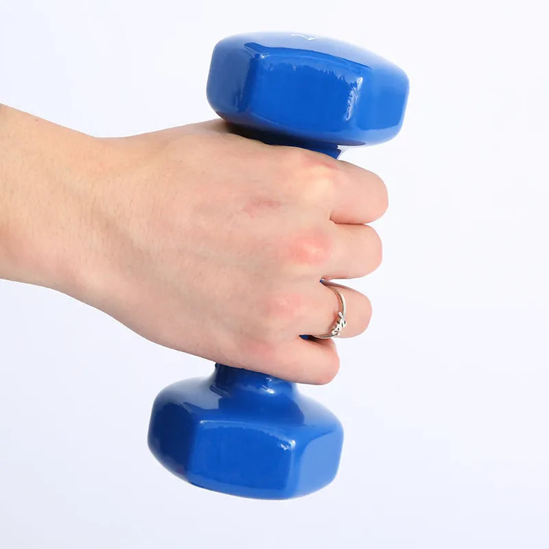 Set of bright green and purple plastic dumbbells on a wooden floor.
