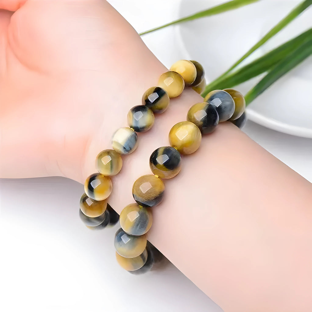 A fantasy tigereye agate bracelet with round beads on a neutral background.