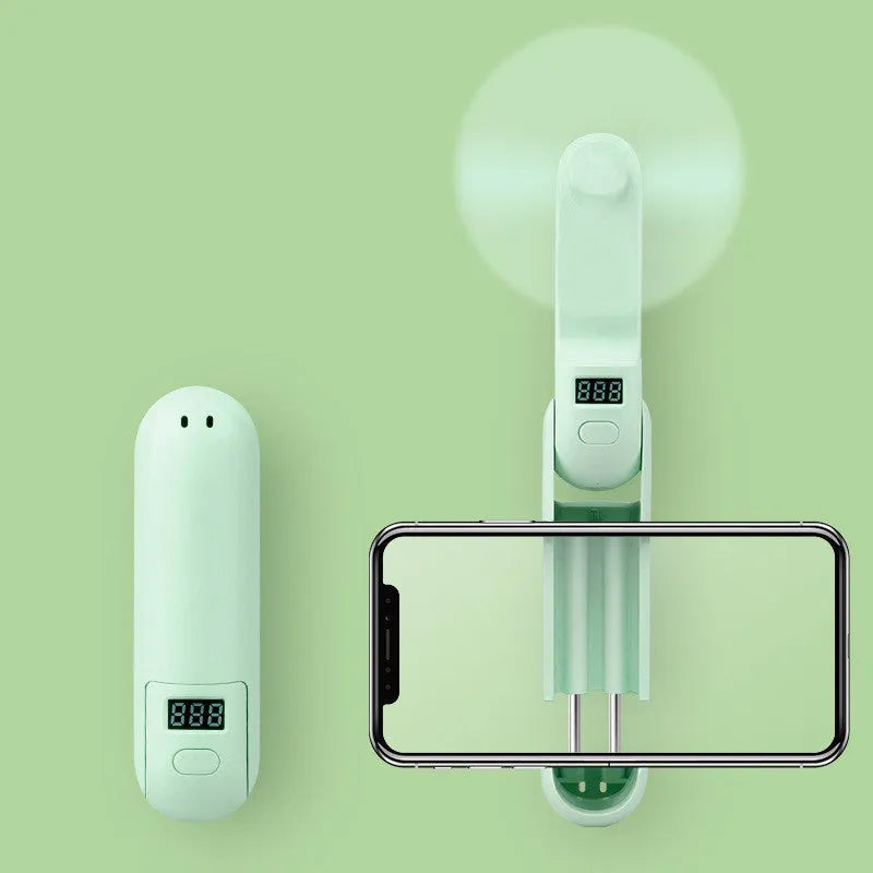 Green folding mini USB fan with plastic blades on a white background.