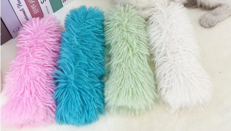 Small green plush pillow cat toy measuring 27cm by 10cm on a plain background