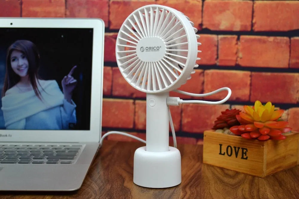 White ORICO FH1 portable USB desk fan with fine-line texture, shown as a handheld and desktop unit.