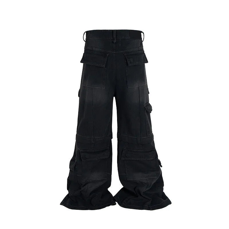 Black washed-out cotton overalls on a hanger, showing detachable pockets and a zip fly.