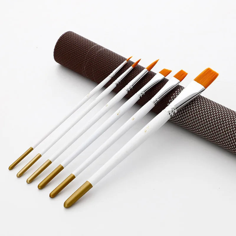 Set of six acrylic and watercolour paintbrushes with wooden handles on a white surface.