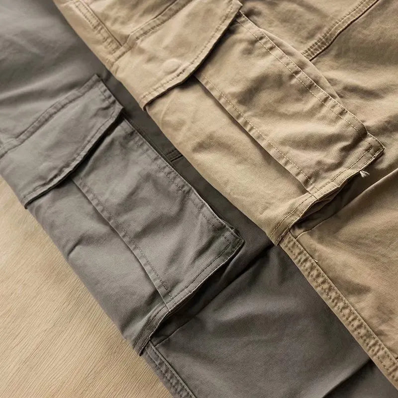Men's cropped multi-pocket cotton work trousers in khaki, shown on a hanger.