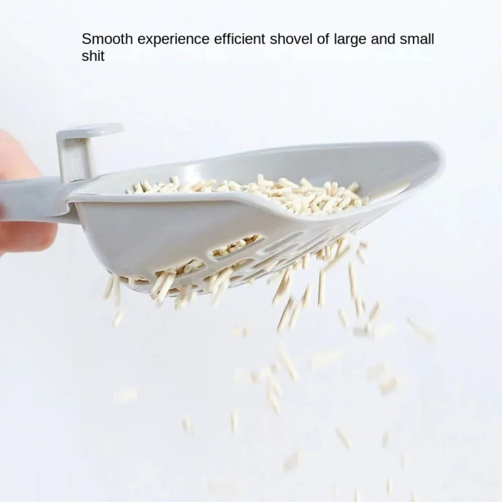 Grey plastic cat litter scoop with drainage holes resting on matching base unit