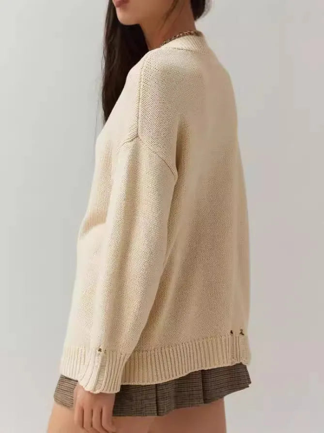Beige women's loose-fitting acrylic sweater with a round neck and textured Jacquard knit pattern.