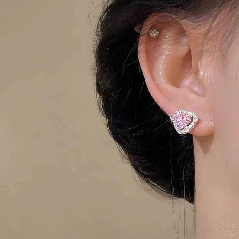 White gold colour heart-shaped stud earrings for women on a jewellery card.