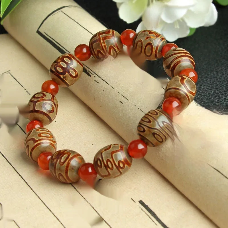 Distressed agate bracelet with traditional Tibetan dzi beads including three-eye and Nine Eyes designs.