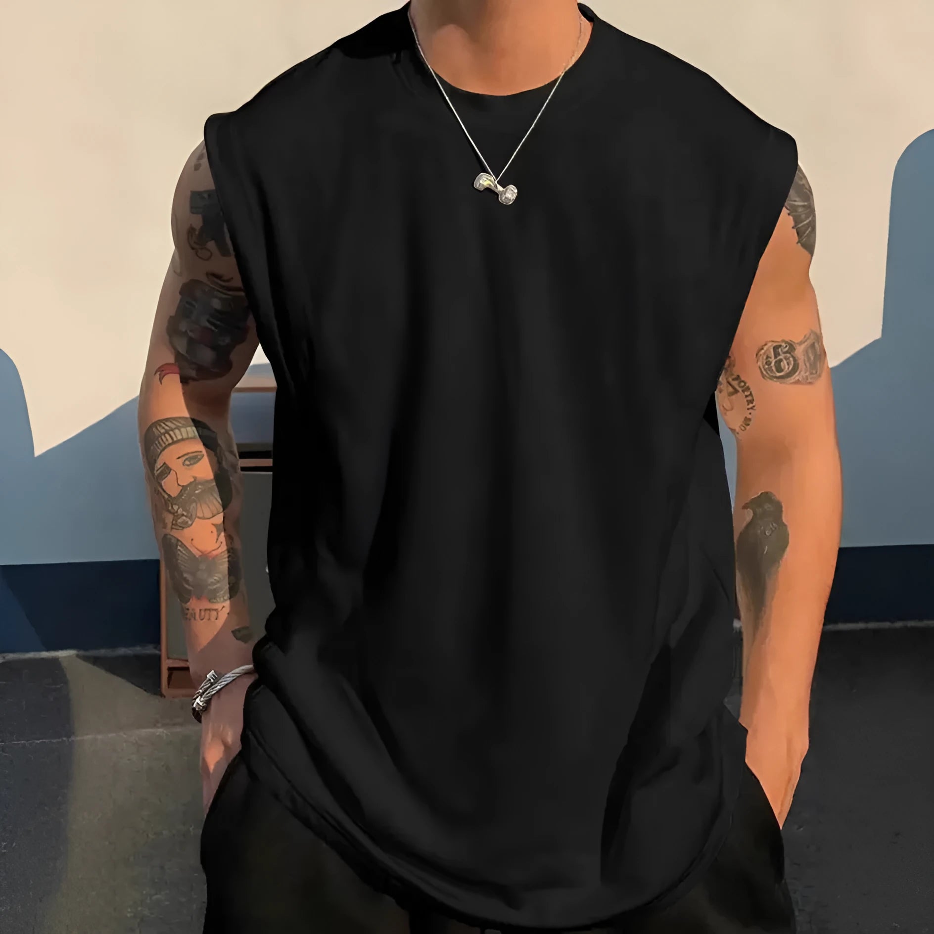 Man wearing a loose apricot-coloured cotton tank top, showing the sleeveless design and straight hem.