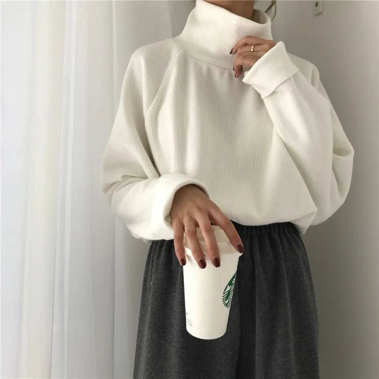 Women's loose fit solid colour long sleeve top with a half-high neck, shown in white.