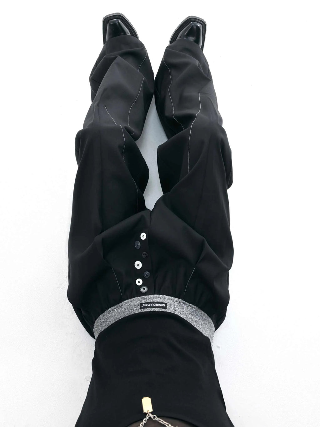Drooping straight-leg trousers with button open line design in black and grey colours