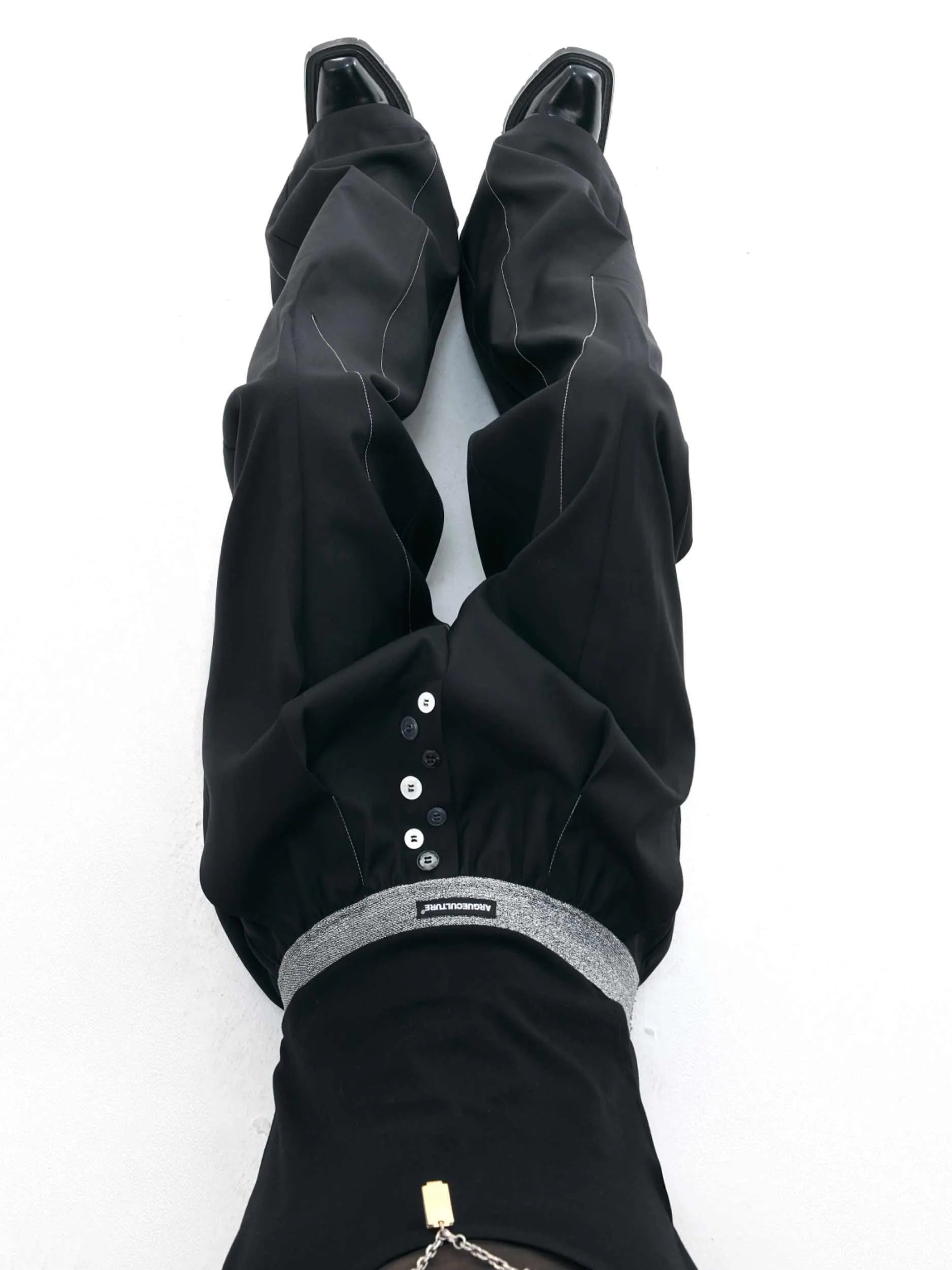Drooping straight-leg trousers with button open line design in black and grey colours
