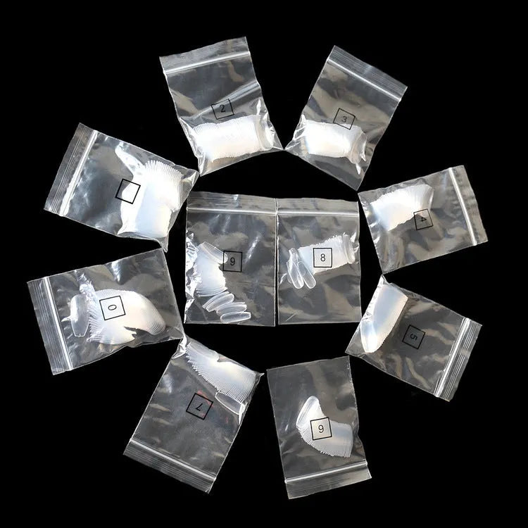 500 clear and natural coloured ABS plastic false nails in ten different sizes arranged on a white surface