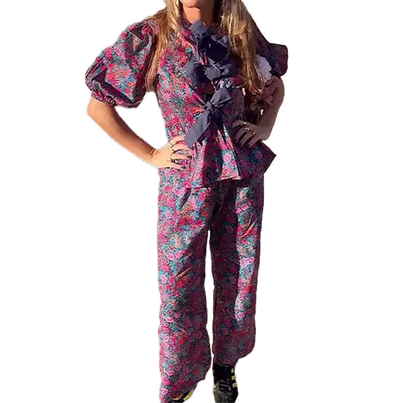 Floral print trousers suit with tie-neck blouse and puff sleeves on hanger