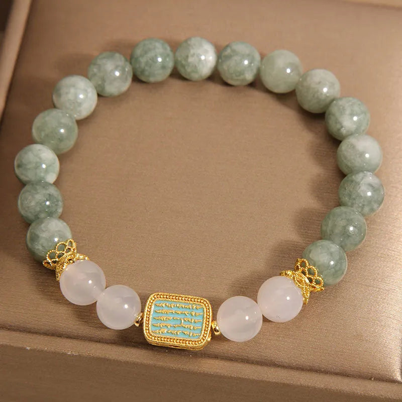 Women's oil green emerald crystal bracelet with five scriptures design on a wrist.