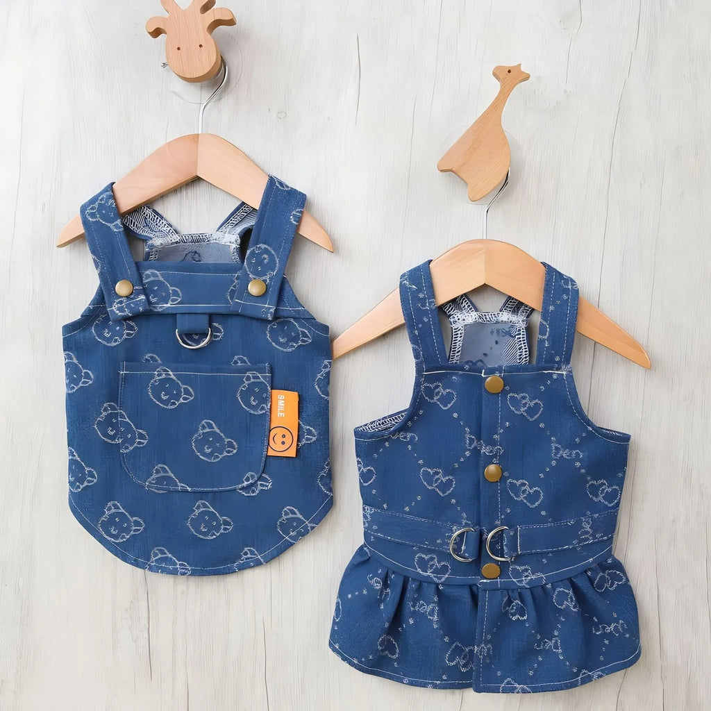 Small white dog wearing a light blue denim bracket-skirt princess dress.