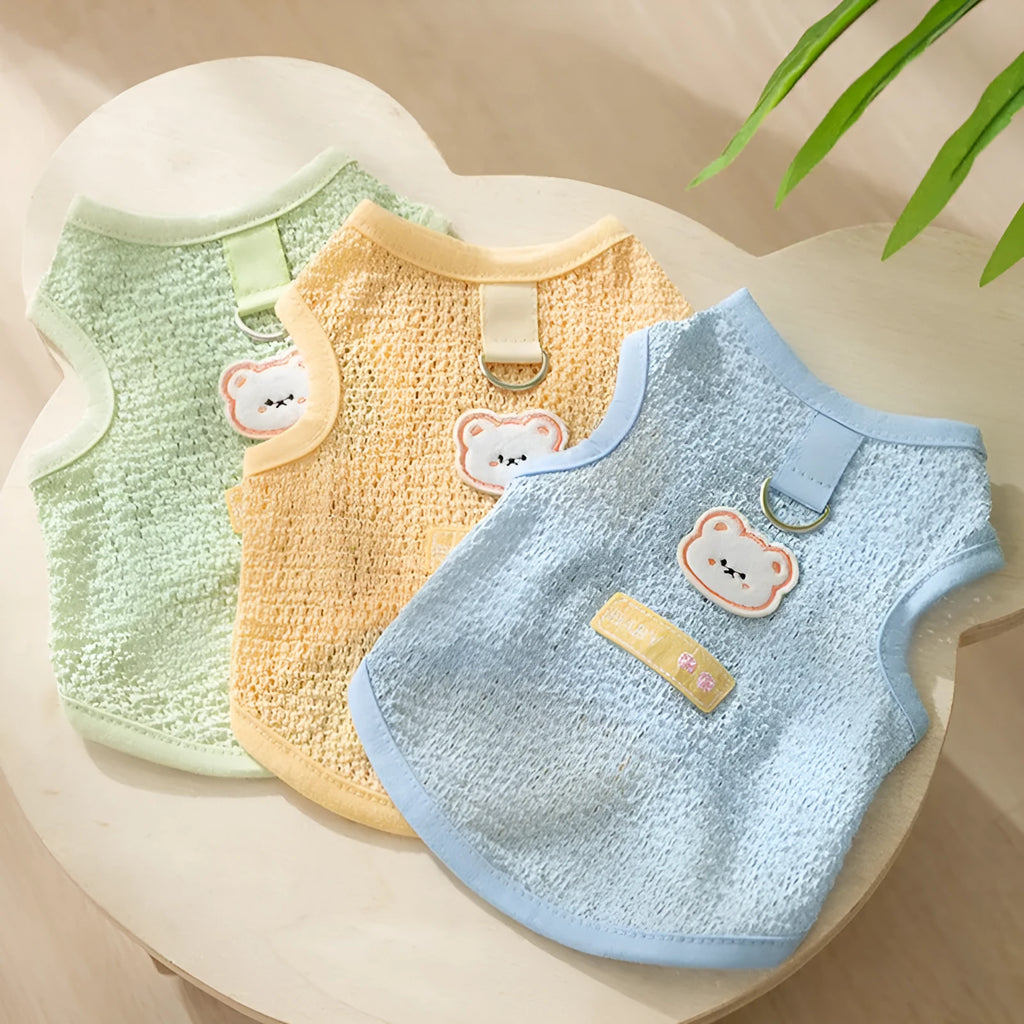 Cat wearing blue bear patch clothing with hollowed-out knitted fabric construction