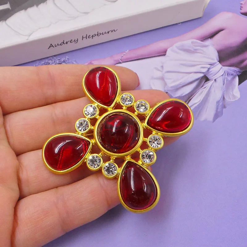Classic vintage zinc alloy brooch with baroque-style cross design and crystal details on a dark background.