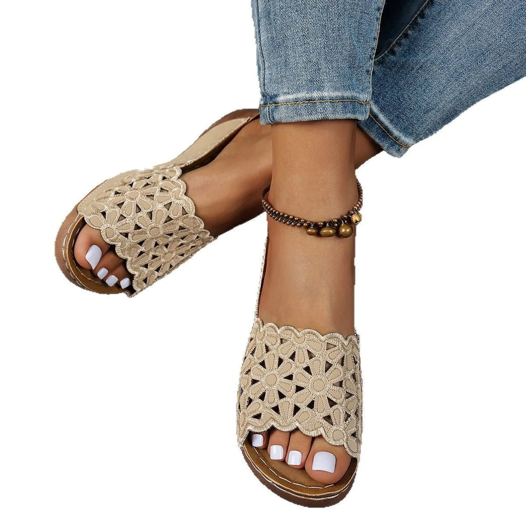 Women's wedge beach slippers with flower cutout design in black colour showing fish mouth toe shape
