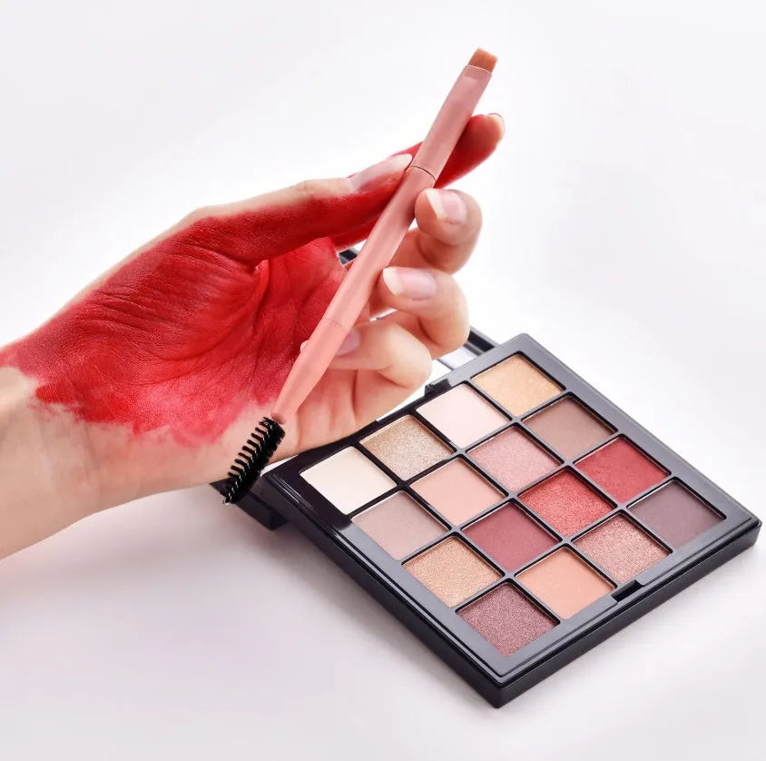 Ten wooden-handle make-up brushes for face and eye application in a pink travel case.