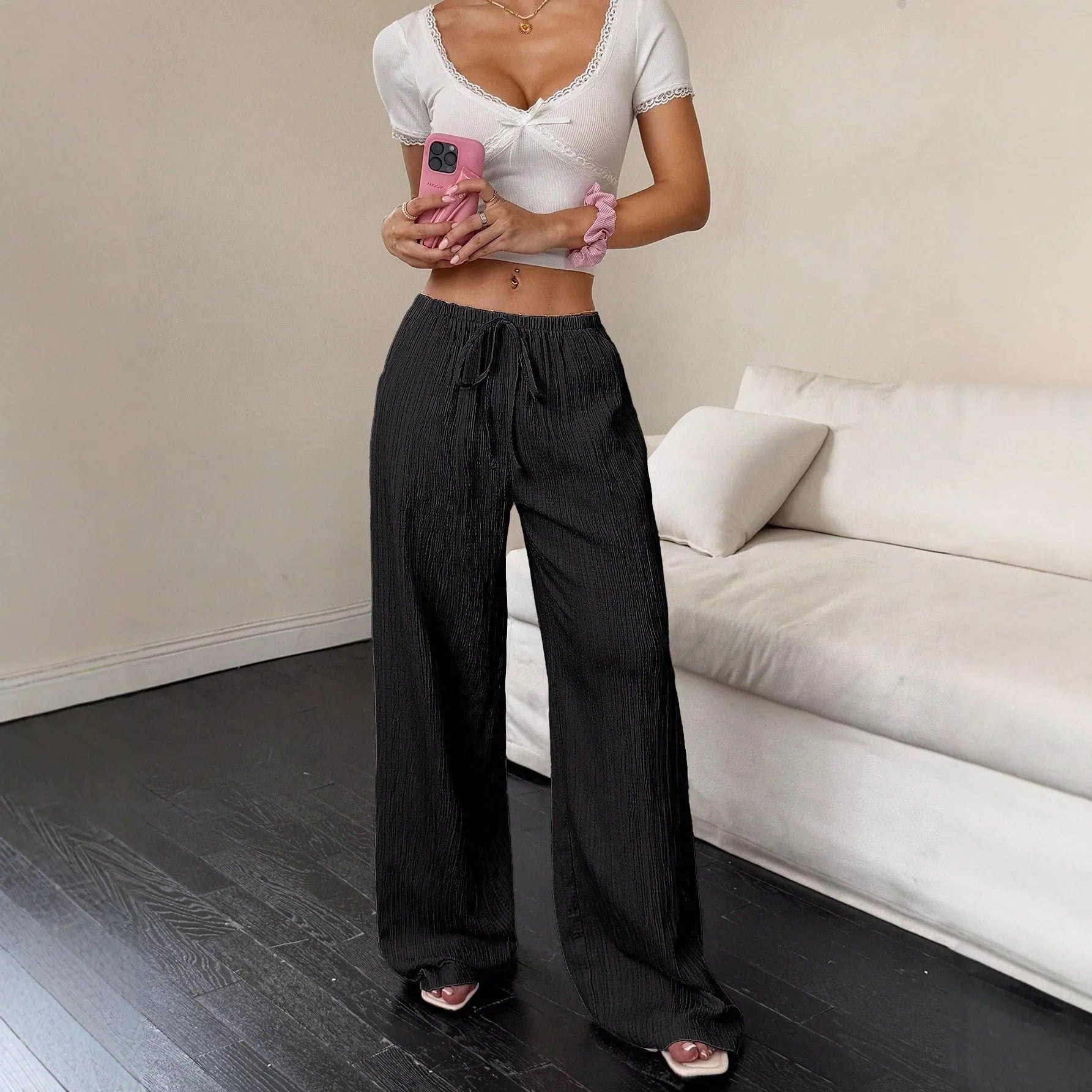 Women's black wide leg trousers with lace-up waist trimming detail on mannequin