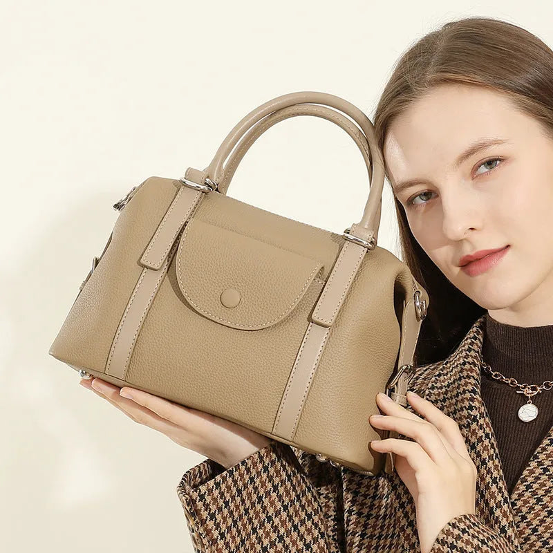 Genuine leather ladies handbag with contrast stitching and lock detail in elephant grey colour