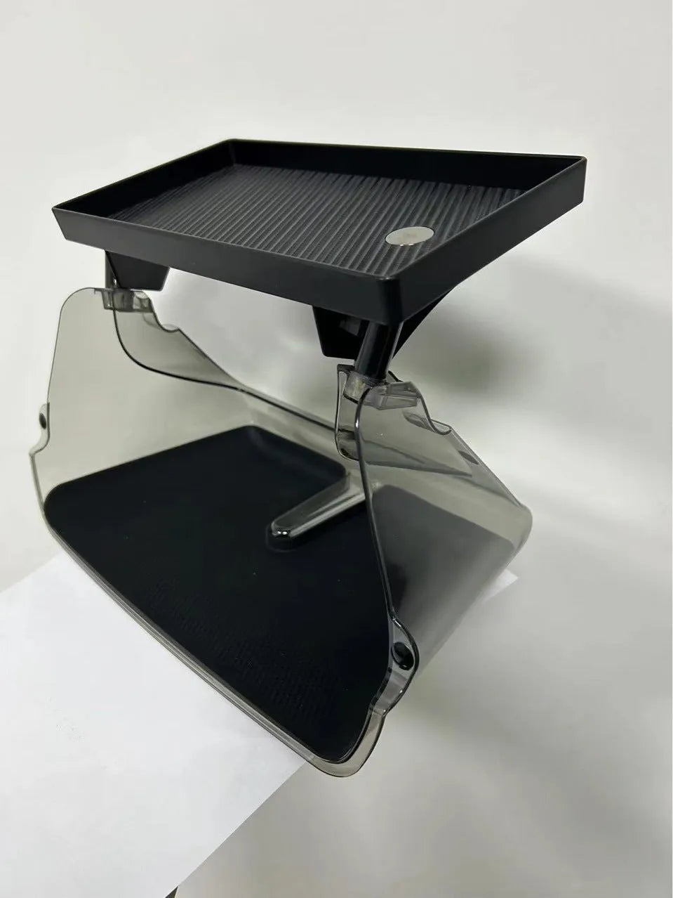 Black ABS plastic storage box installed under the touchscreen in a Tesla Model Y centre console.