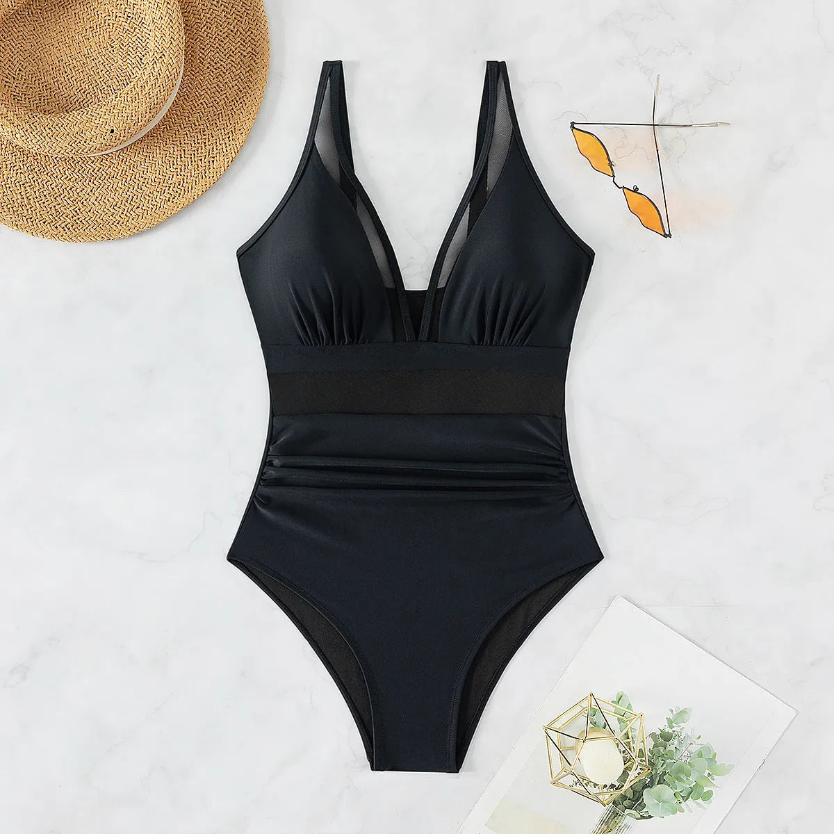 Black women's halter neck one-piece swimsuit with mesh panels and briefs style bottom.