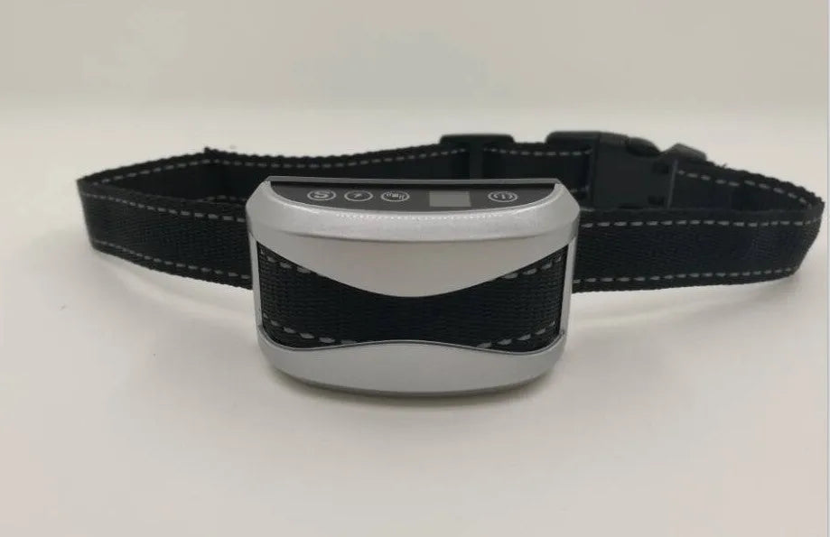 Black digital dog bark training collar with adjustable reflective strap on a table