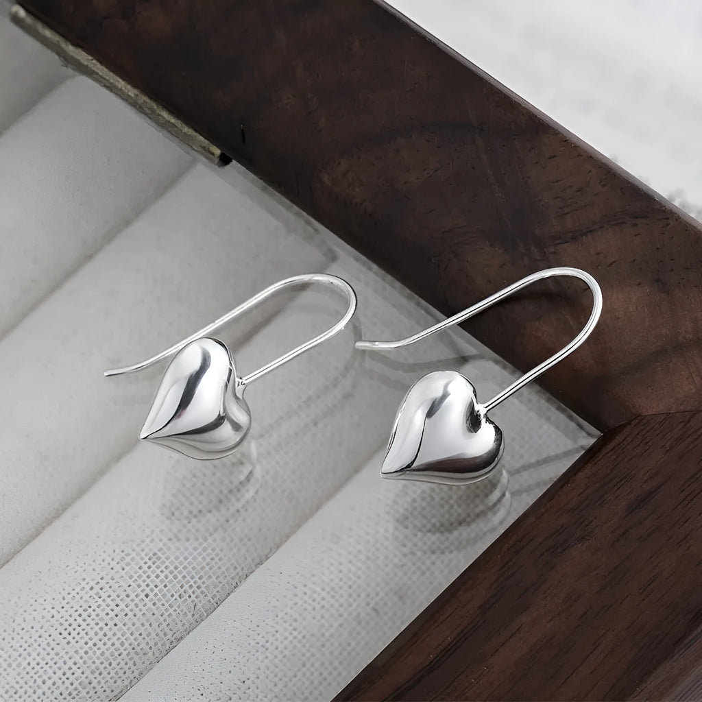 Silver heart-shaped copper earrings with three-dimensional glossy finish and Korean-style design