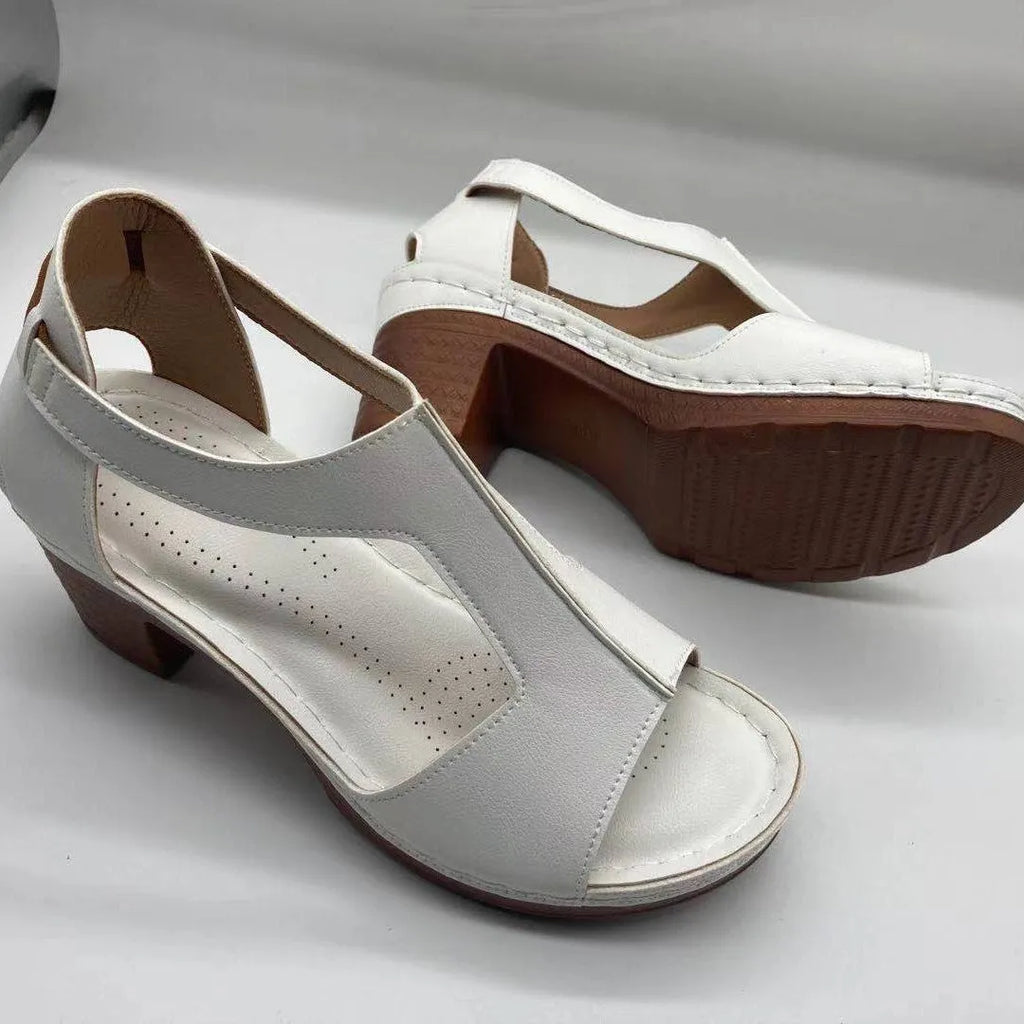 Women's peep toe wedge sandals with Roman-style buckle on a low heel.