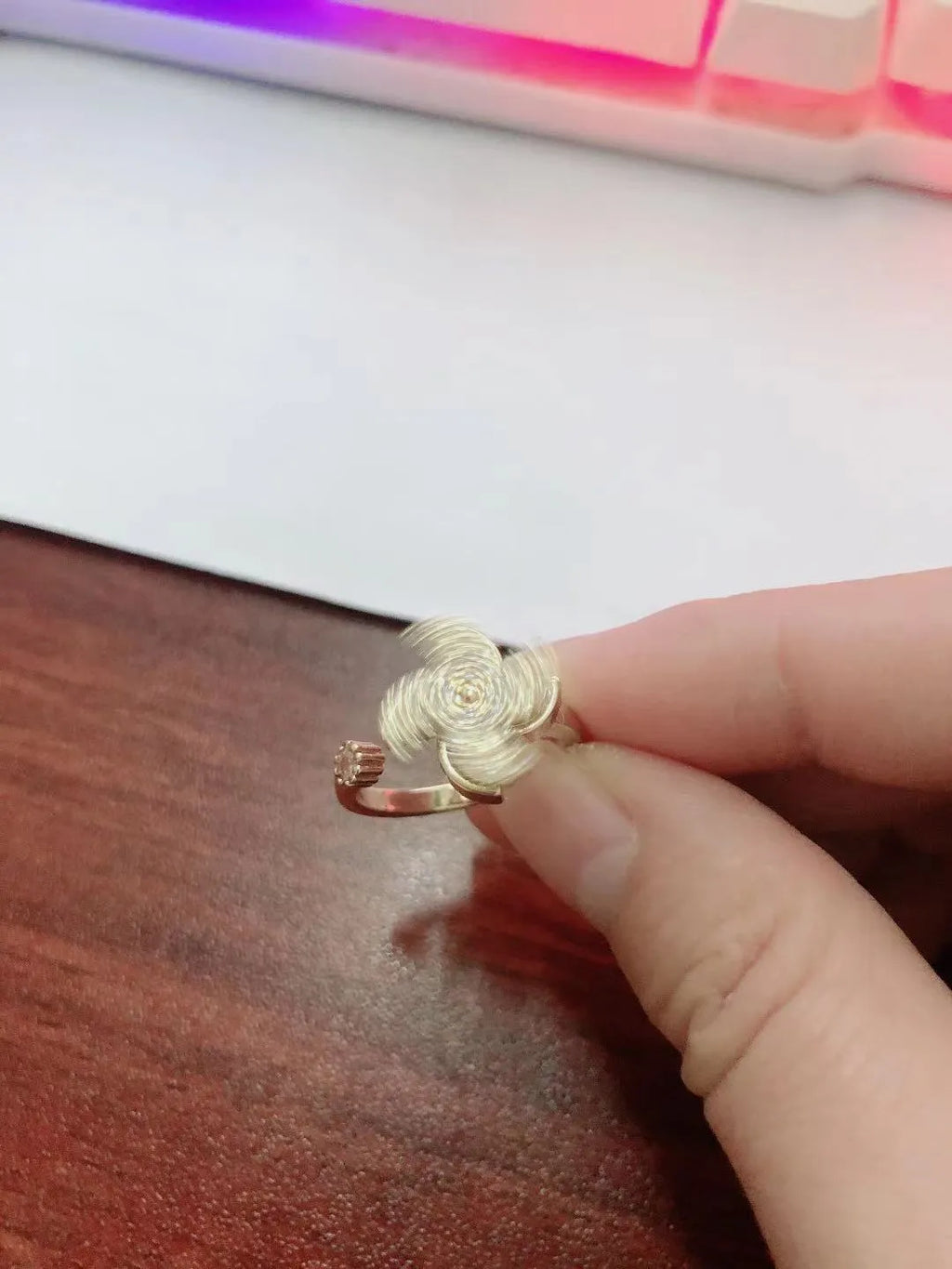Rotating geometric windmill ring in gold or silver finish on a copper band.