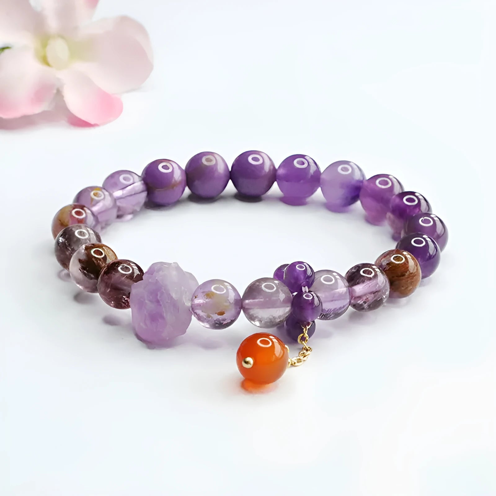 Natural nine purple amethyst and red agate multi-treasure crystal bracelet on wrist.