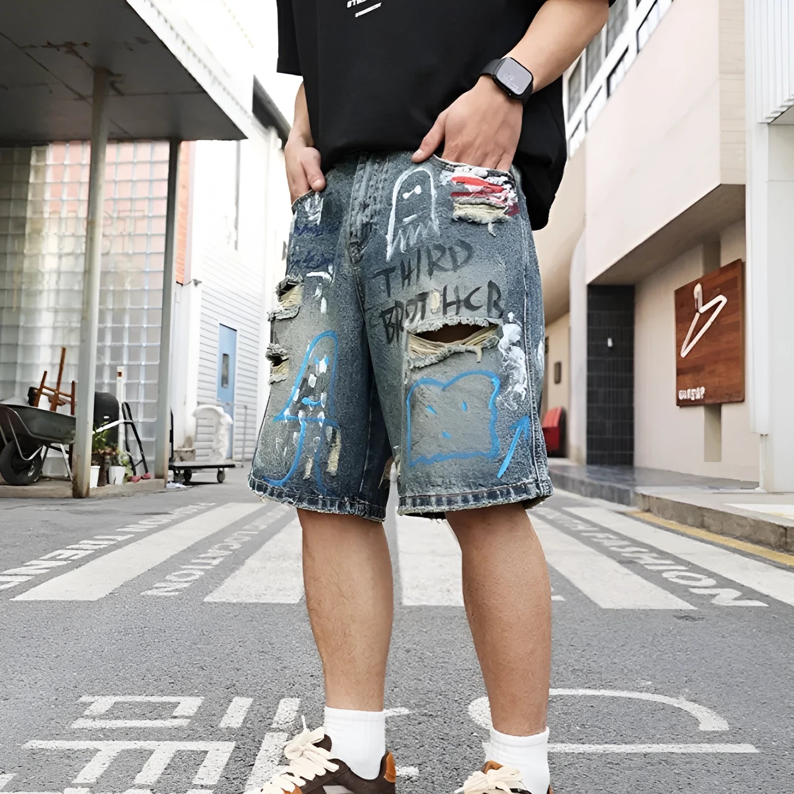 Blue denim shorts for men with ripped knees and graffiti print, featuring a straight leg and a zipper fly