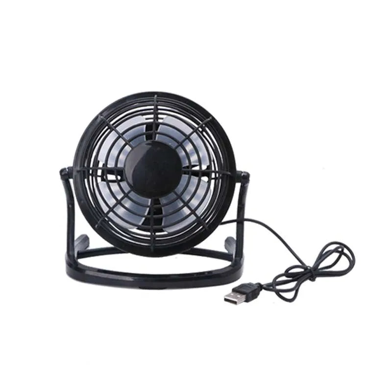 Mini black USB desk fan with adjustable angle on wooden desk next to laptop