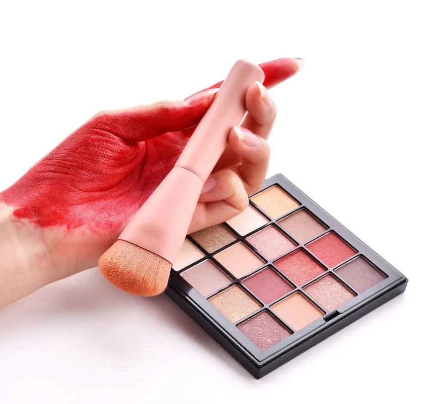 Ten wooden-handle make-up brushes for face and eye application in a pink travel case.