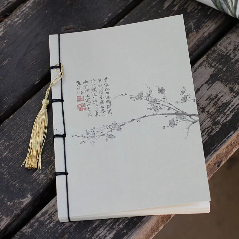 A5 antique wire-bound notebook with glossy embossed cover featuring a retro painting design, shown open.
